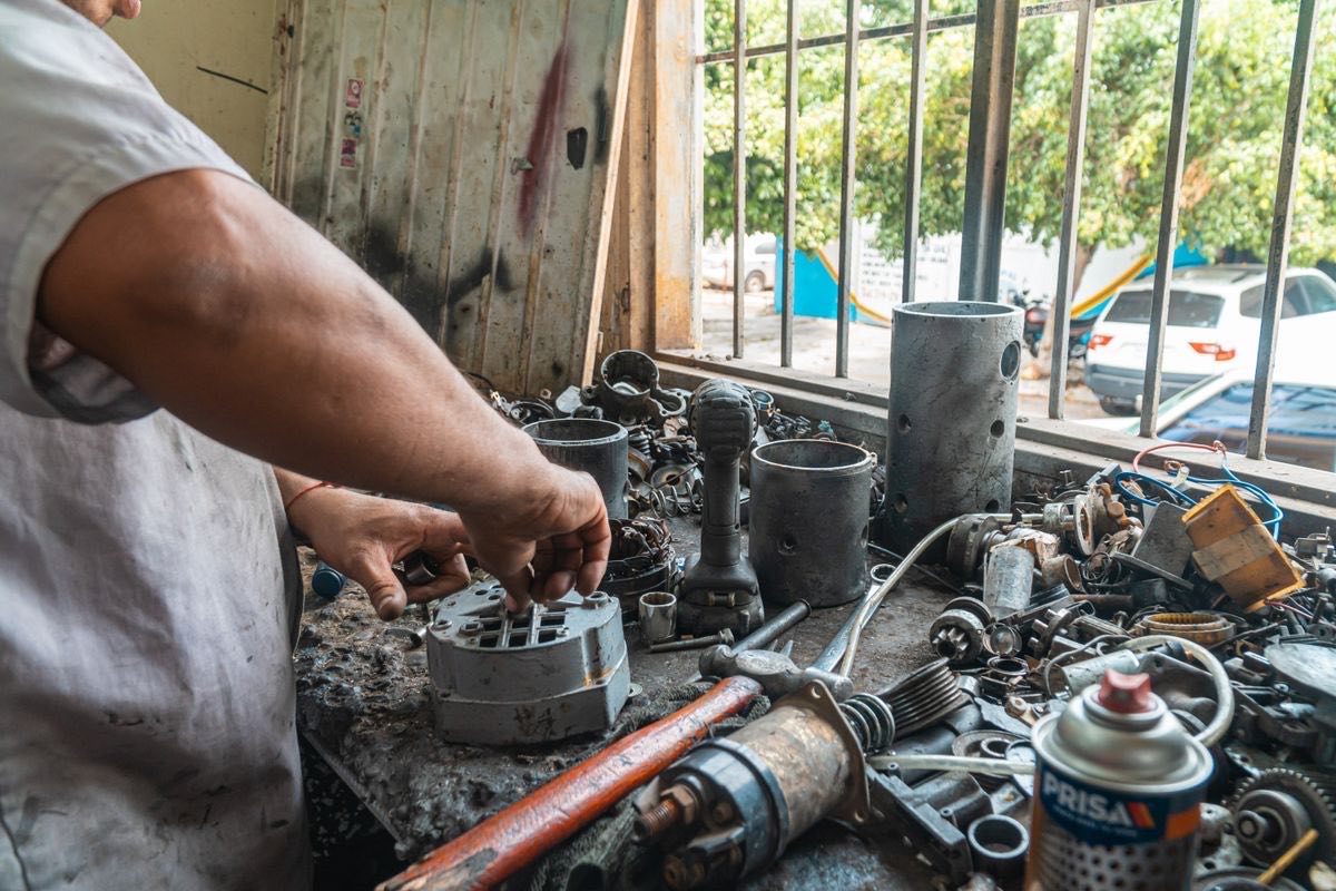 A mechanic working on engine components at a parts counter